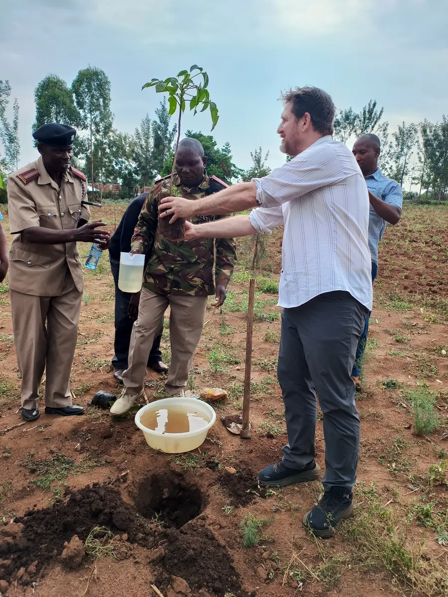 Community members and program partners planting a tree